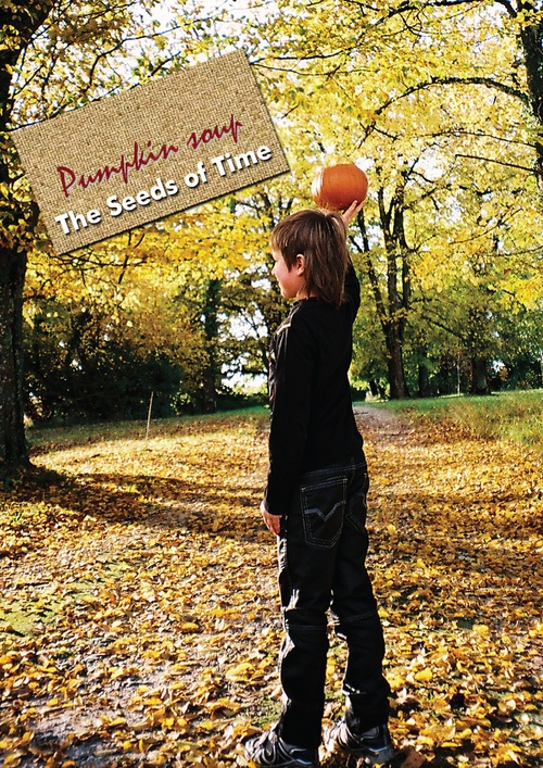 Poster art for album titled Pumpkin Soup by The Seeds of Time on which there is a photograph of a boy holding a pumpkin above his head while standing in a forest surrounded by an autumn scene and yellow leaves